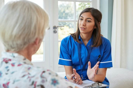 Licensed healthcare provider conducting comprehensive in-home medical visit with patient, providing personalized care including physical exam and medication review